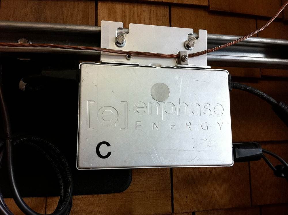 Enphase M190 mikroinvertori panel ostidagi relsga o'rnatilmoqda. Har bir panel o'zining kichik invertoriga ega bo'ladi.